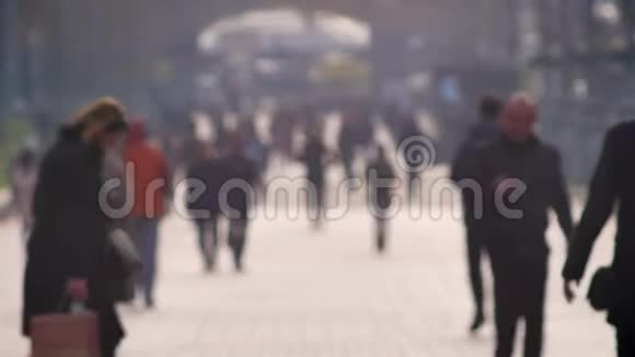 在白天的城市背景下模糊的街道上的行人在路上奔跑和行走视频的预览图