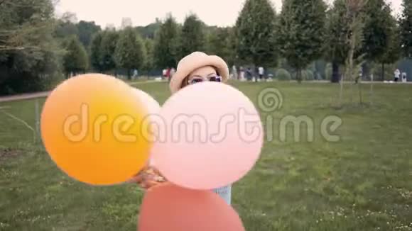 戴着墨镜戴着气球奔跑旋转的姜姑娘微笑视频的预览图