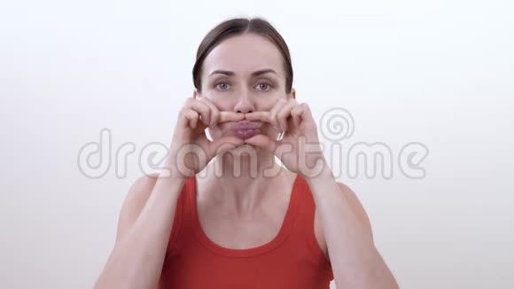 一个黑发女人做面部运动的肖像以塑造嘴唇减少下垂的皮肤并调整你的嘴唇肌肉视频的预览图