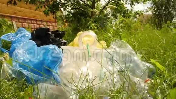 地球污染和环境灾难的概念在绿草上看一下用过的塑料瓶视频的预览图