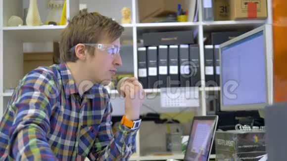 一个工程师设计师在计算机上的工作改变3D打印机设置视频的预览图