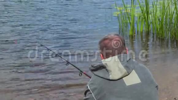 钓鱼的人坐在水边视频的预览图