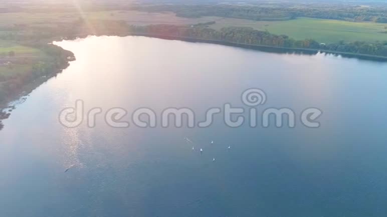 日落时高空观帆船漂浮在水面湖泊上视频的预览图