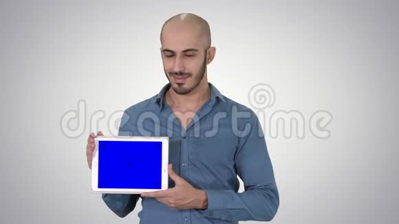 微笑休闲男子呈现平板电脑与空白屏幕上的梯度背景视频的预览图