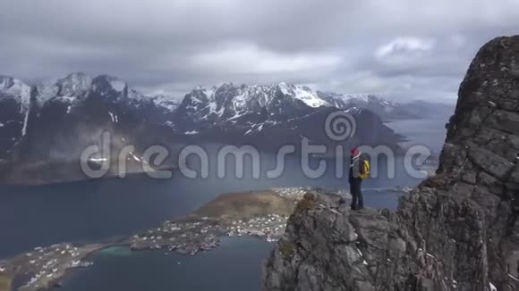 台湾群岛风景秀丽的洛佛顿群岛风光山顶上男性徒步旅行者的空中镜头视频的预览图