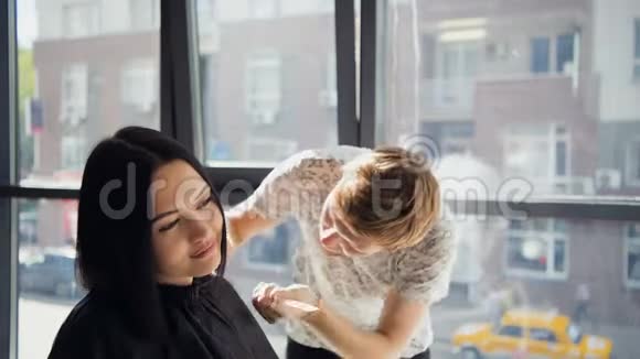 在理发师一位满脸笑容的黑发女人在一家理发店里在一位男理发师面前给她理发视频的预览图