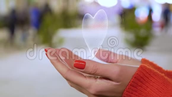 女性双手握着一个白色心脏的概念全息图视频的预览图
