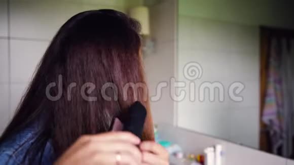 年轻的女人在浴室里整理头发美容概念视频的预览图
