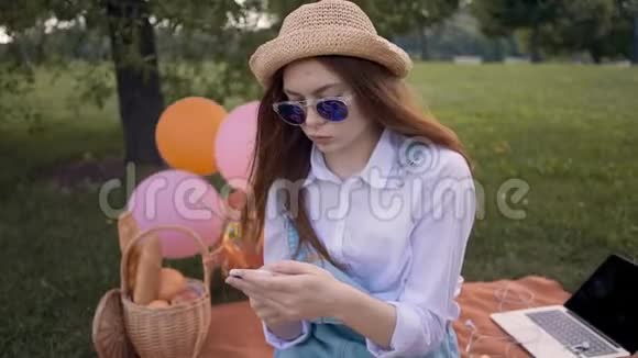 戴着草帽戴着墨镜的姜红大学生在公园里微笑视频的预览图