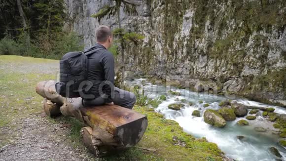 男子旅游徒步旅行者带背包欣赏风景秀丽的山河景观旅行徒步旅行者远离旅行人们视频的预览图