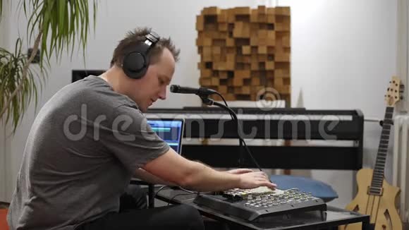 音乐家在家庭音乐工作室唱歌和演奏MIDI键盘视频的预览图