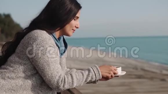独自浪漫的女人早上在阳台上喝咖啡海景视频的预览图