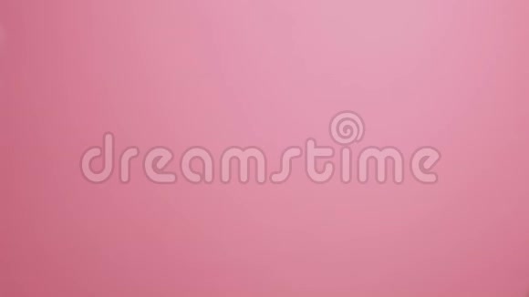 一位年轻女子的手在粉红色的画室背景上欢快地拍手视频的预览图