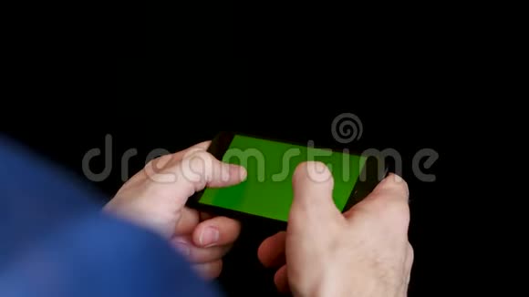一个工作场所的男人用智能手机用绿色屏幕检查财务报告点击屏幕打字视频的预览图