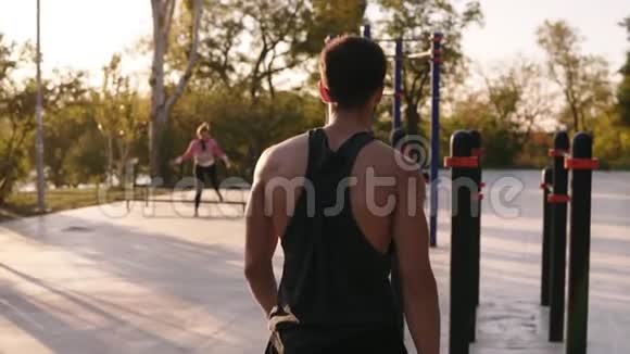 穿着衬衫的肌肉男来到当地运动场开始在水平横杆上训练三头肌视频的预览图