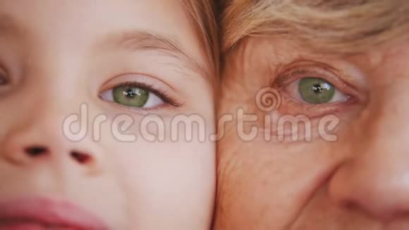 特写祖母和孙女的肖像绿色的眼睛视频的预览图