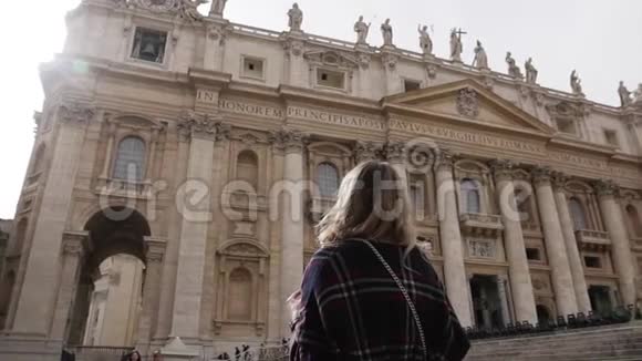 戴着墨镜手里拿着智能手机的女人看着梵蒂冈的圣彼得教堂慢动作稳定视频的预览图