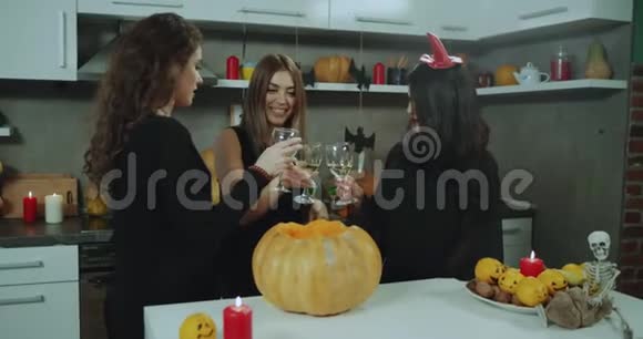 三个蒙面女孩在万圣节派对上喝着酒聊得很开心周围都装饰着视频的预览图