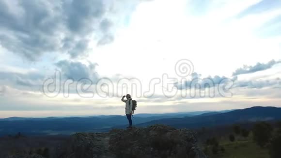 徒步旅行者站在山峰上环顾四周视频的预览图