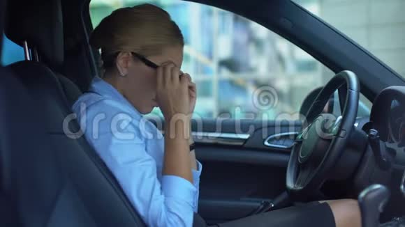 沮丧的女商人摘下眼镜坐在车里为失败而沮丧视频的预览图