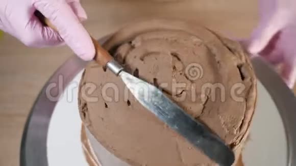 糕点厨师女士在海绵蛋糕上涂抹巧克力奶油视频的预览图