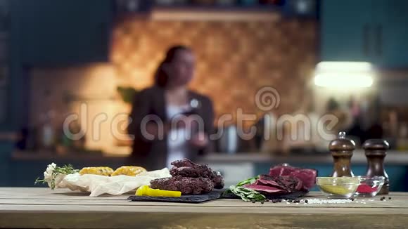 切肉汉堡烤肉玉米和香料站在桌子上在背景中一个年轻女孩失去了焦点视频的预览图
