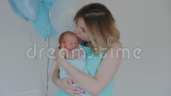 快乐的母亲抱着她的新出生的婴儿亲吻和拥抱生育观念为人父母做母亲美丽美丽视频的预览图