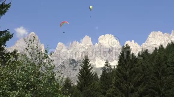 两个滑翔伞飞行在多洛米蒂山脉和森林视频的预览图