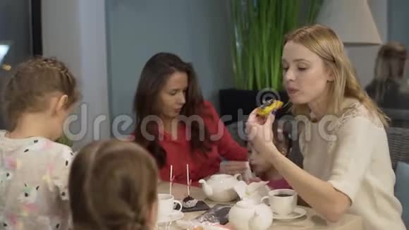 母亲和三个孩子在咖啡馆里吃饭和聊天视频的预览图