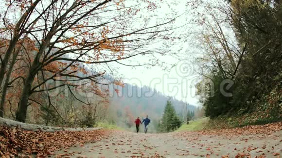 女徒步旅行者带着小背包在森林里的乡村道路上奔跑视频的预览图