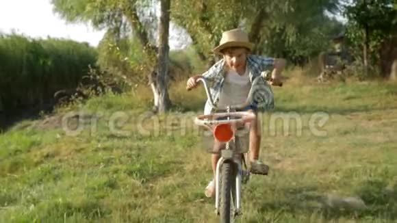 快乐的童年孩子骑着自行车在乡村的湖和自然的背景下视频的预览图