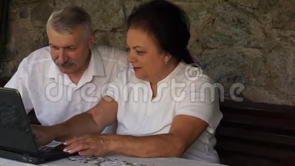 带笔记本电脑的成年老年夫妇视频的预览图