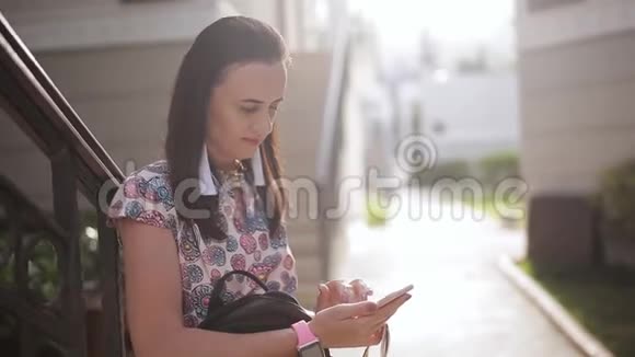 一个女人在家附近使用智能手机等待视频的预览图