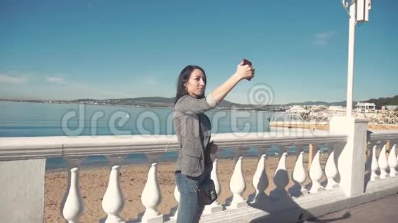 在海滩的地平线上一位女士用智能手机相机拍照年轻女孩拍照视频的预览图