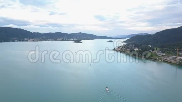 鸟瞰群山中的一个大湖船在湖上移动克拉根福卡林西亚奥地利视频的预览图