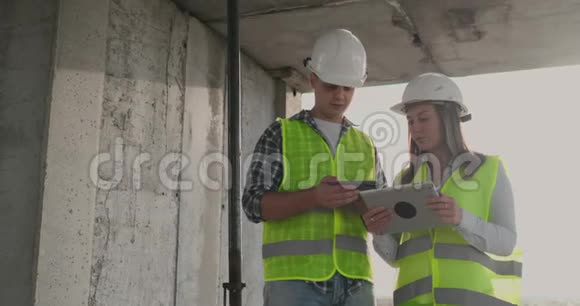 工程师们站在正在施工的建筑物的屋顶上讨论计划和进度视频的预览图