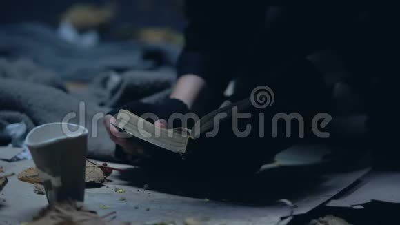 无家可归的移民躺在地上读圣经希望和信仰祈祷视频的预览图