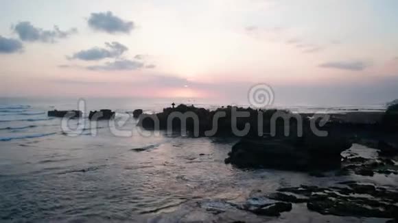 巴厘岛黑色海滩的寺庙和海水的鸟瞰图视频的预览图