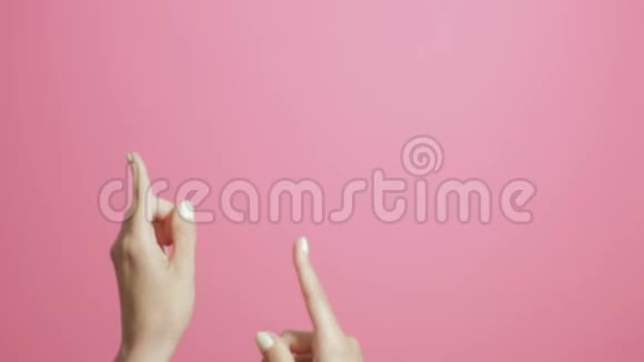 女孩手指举着女孩在粉红工作室的背景上积极打手势视频的预览图