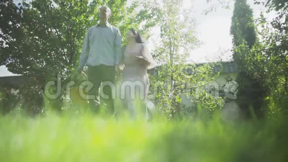 一对成年夫妇正拥抱在花园里散步视频的预览图