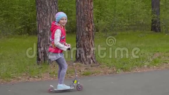 可爱的青春期少女骑着脚踏车在公园的路上视频的预览图