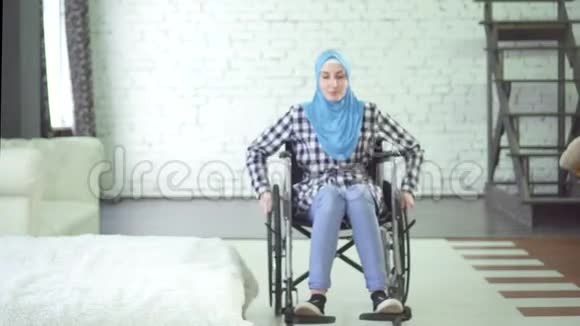 戴头巾的坐轮椅坐公寓的年轻美女视频的预览图