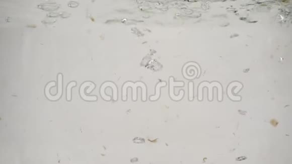 在白色背景下三只蘑菇香瓜慢慢沉入沸水中视频的预览图