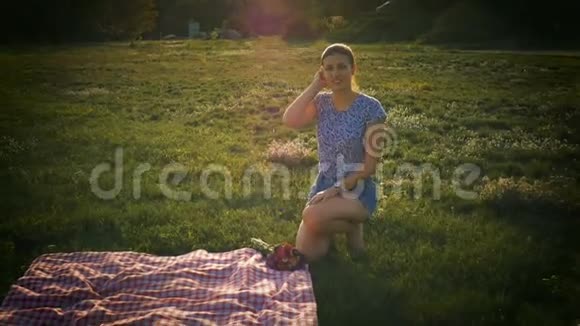 坐在草坪上看镜头的女孩视频的预览图