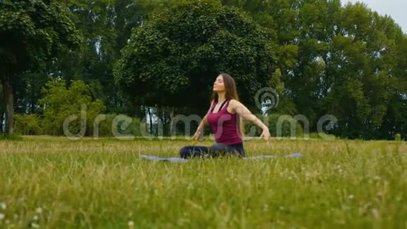 年轻漂亮的女人在户外练习瑜伽健康观念平静和放松女人的幸福视频的预览图