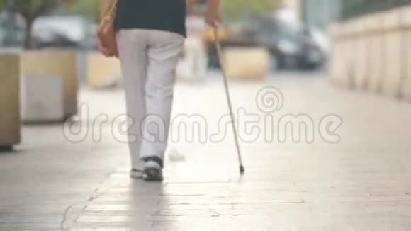 拄着拐杖的老妇人在街上散步视频的预览图
