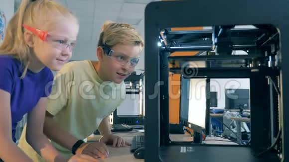 孩子们看着一台现代3D打印机工作回到学校的概念视频的预览图