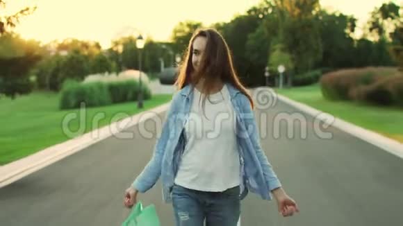 快乐的女人穿着包在城市公园散步快乐女孩视频的预览图