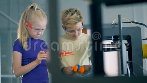 学龄儿童使用打印机手持3D塑料模型视频的预览图