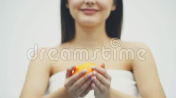这幅画描绘了一位迷人的白种人微笑的女人她被隔离在白色的工作室背景上带着橙色的水果美丽视频的预览图